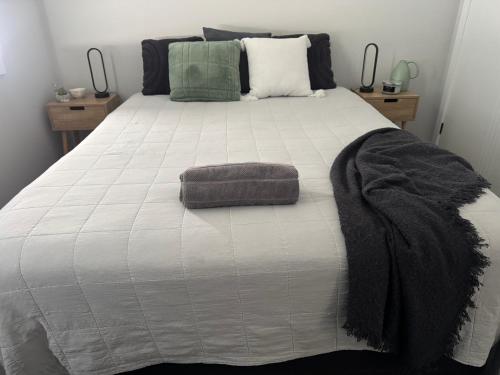 a bed with a black and white comforter at Entire 4 bedroom home on Connolly in Bathurst in Kelso