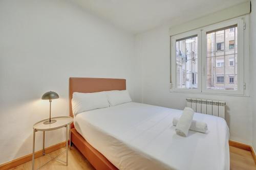 ein Schlafzimmer mit einem weißen Bett und einem Fenster in der Unterkunft El Encanto de Huesca by Clabao in Logroño