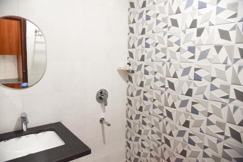 a bathroom with a sink and a mirror at Hotel Om Regency in Ghaziabad