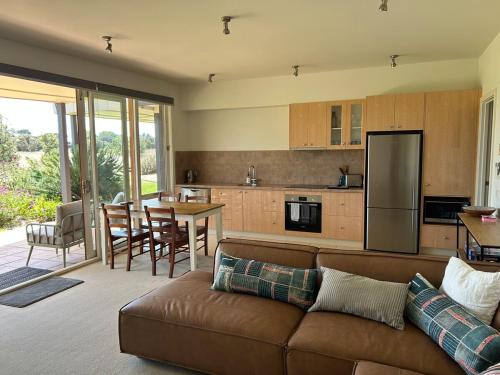 a living room with a couch and a kitchen at 13th Beach 2-Bedroom Golf Apartment in Connewarre