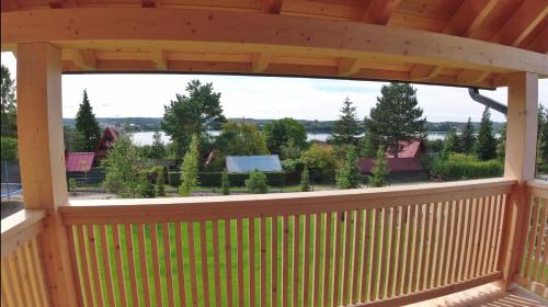 a wooden gazebo with a view of a yard at Czôrny Dąb - nowoczesny dom wakacyjny na Kaszubach, jacuzzi, sauna, bilard in Garcz