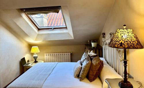 a bedroom with a bed with a lamp and a window at Holibai, Lembrare, Ático a unos pasitos de la playa, Baiona in Baiona