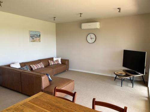 a living room with a couch and a tv at 13th Beach 2-Bedroom Golf Apartment in Connewarre