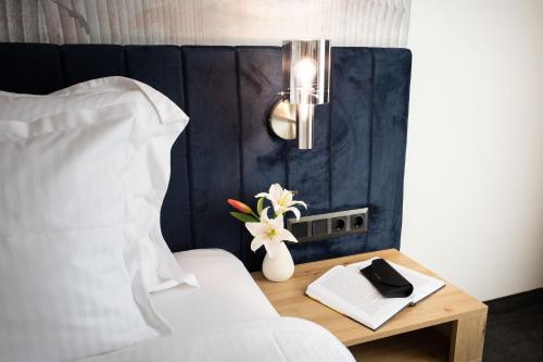 a bedroom with a bed and a table with a vase of flowers at Blue Star Luxury Hotel in Sofia