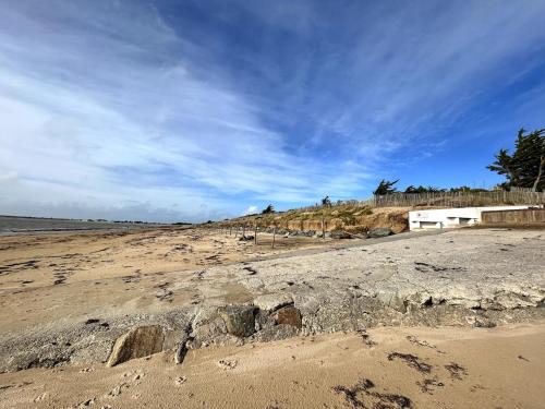 a beach with some rocks on the sand at Lovely fully renovated beach villa in La Guérinière