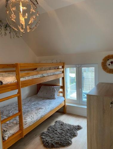 - une chambre avec 2 lits superposés et un lustre dans l'établissement Charmante maison proche de la mer et des commerces, à Trégunc