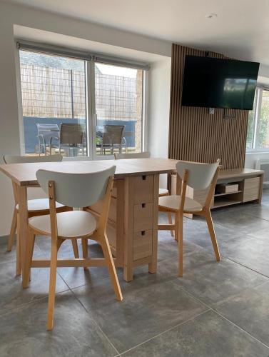 une salle à manger avec une table et des chaises et une télévision dans l'établissement Charmante maison proche de la mer et des commerces, à Trégunc
