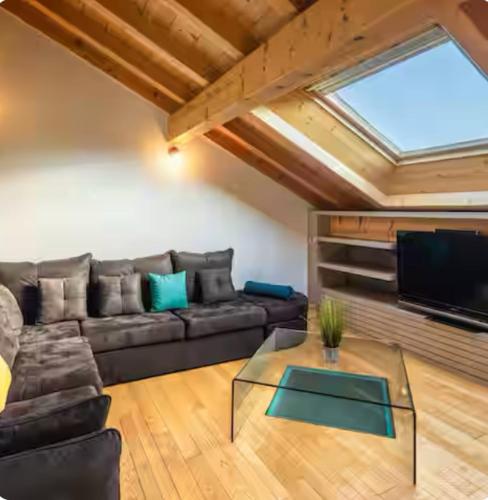 un salon avec un canapé et une télévision dans l'établissement La Tourbière, à Entre-Deux-Monts