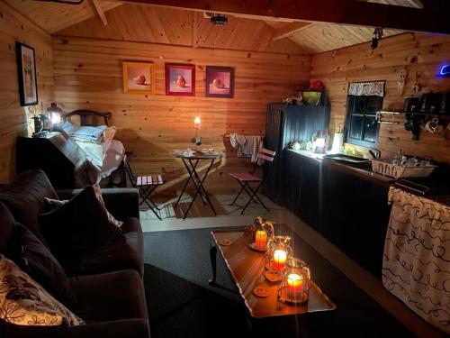Cette chambre dispose d'une cabane en rondins avec des bougies sur une table. dans l'établissement L'étang magique, à Plénée-Jugon