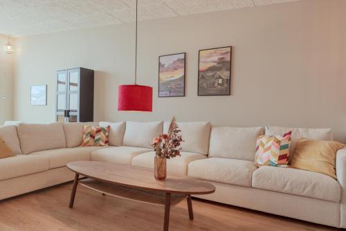 a living room with a couch and a table at By The Sea - Boathouse with Hot Tub & Parking in Vestmanna