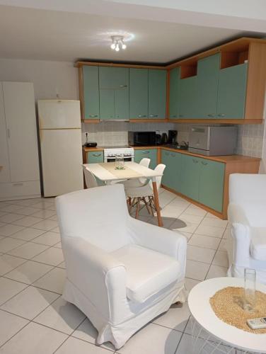 a kitchen with green cabinets and white chairs and a table at S & K GROUND FLAT in Vrilissia in Athens