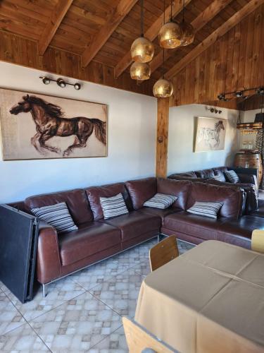 a living room with a brown leather couch at Hospedaje Shuyen in Victoria