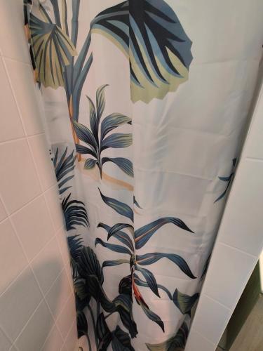 a white shower curtain with plants on it in a bathroom at De Vert et d'Or - proche gare - parking - jardin in Saint-Brieuc