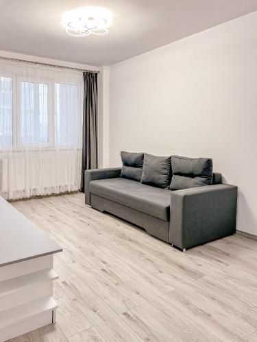 a living room with a couch in a white room at Nordic Residence NH 42 in Suceava
