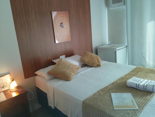 a hotel room with a bed with two pillows on it at Paradise Beach in Fortim