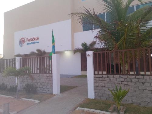 a building with a flag in front of it at Paradise Beach in Fortim