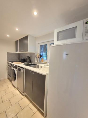 a kitchen with a sink and a refrigerator at Maison L'Estuaire 15 minutes Rouen Free parking in Grand-Couronne
