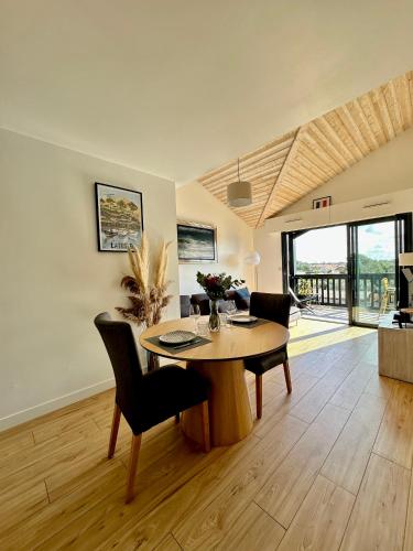 un salon avec une table et des chaises en bois dans l'établissement Appartement 50m2 - 1ère Ligne Vue Port de La Teste, à La Teste-de-Buch