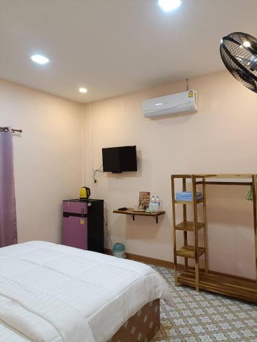 a bedroom with a bed and a tv on the wall at วรรณรีสอร์ทwanresort in Seka