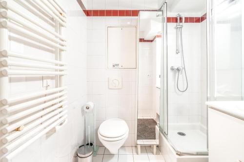 une salle de bain blanche avec toilettes et douche dans l'établissement Champs Elysees Flat, à Paris