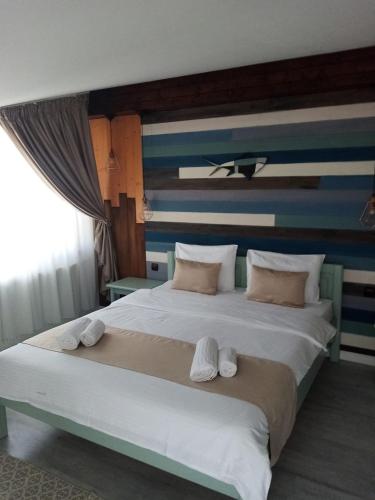 a bedroom with a large bed with towels on it at Stanca Dunarii in Nufăru