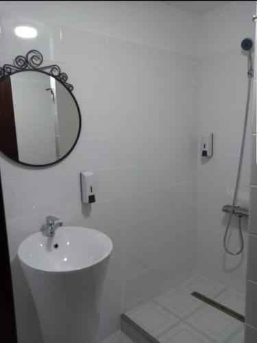a white bathroom with a sink and a mirror at Stanca Dunarii in Nufăru