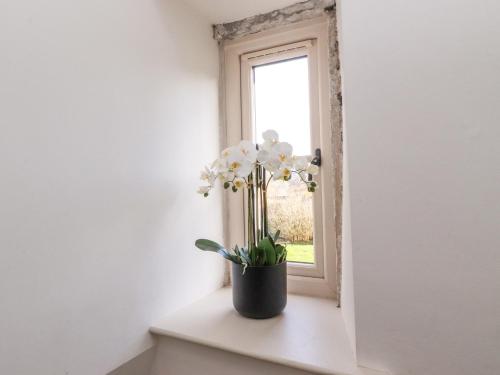 a vase of flowers sitting on a window sill at The Old Cobblers in Skipton