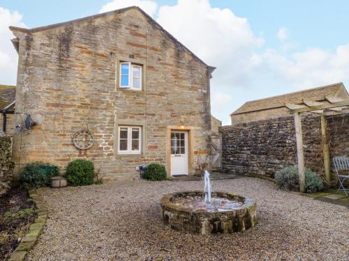 a stone house with a fountain in front of it at The Old Cobblers in Skipton