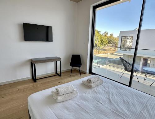 a bedroom with a bed with two towels on it at Elysian Blue villa 2 in Paphos City