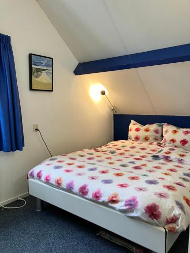 a bedroom with a bed with flowers on it at Klinket Zoutelande in Zoutelande