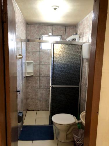 a small bathroom with a toilet and a shower at Residencial BomAluguel in Capão da Canoa