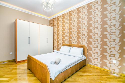 a bedroom with a bed and a cabinet in it at Apartment BİCOCCA in Baku