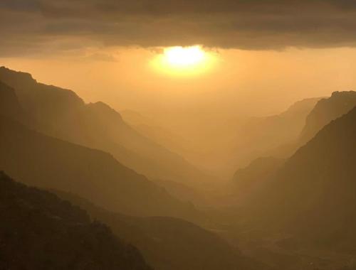 a view of the sun setting over a mountain range at Dana Trail Hotel in Dana