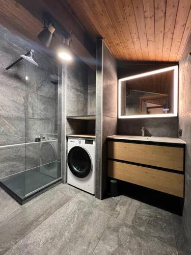 La salle de bains est pourvue d'un lave-linge et d'une douche. dans l'établissement Appartement Megève, piscine et aires de jeux enfants, à Megève