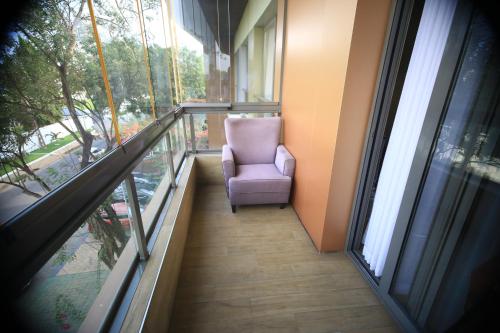 a purple chair sitting on the balcony of a building at PLS Apartments Pearl-Cantonment One Bedroom in Nima