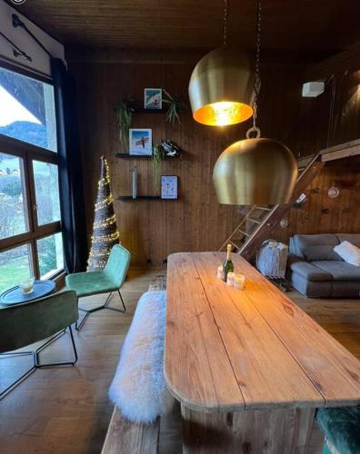 - un salon avec une table en bois et un arbre de Noël dans l'établissement Appartement Megève, piscine et aires de jeux enfants, à Megève