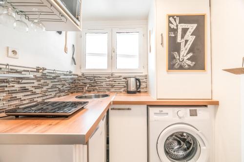 une cuisine avec un évier et une machine à laver dans l'établissement Chatelet Flat, à Paris