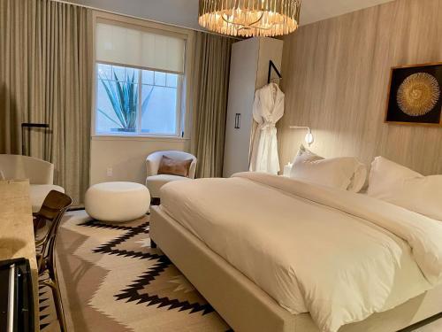 a bedroom with a large white bed and a chair at Palace Modern Hotel at the Plaza in Santa Fe