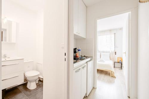 une salle de bain blanche avec des toilettes et un lavabo dans l'établissement Amelot Mobilite, à Paris