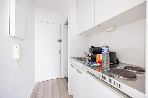 une cuisine blanche avec un évier et un plan de travail dans l'établissement Amelot Mobilite, à Paris