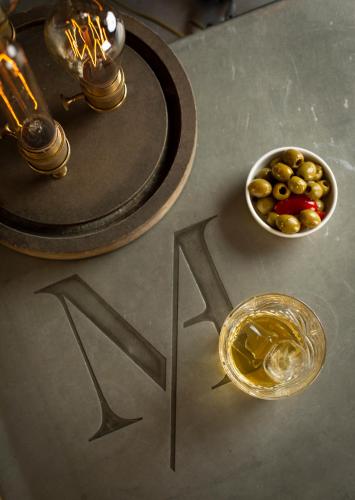 a table with a bowl of olives and a drink at Maison D'Anthouard in Écully
