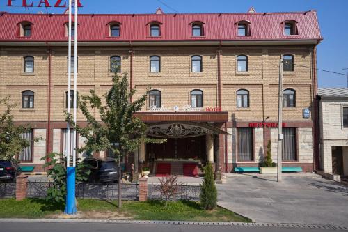 a large brick building with a red roof at Rakat Plaza in Tashkent