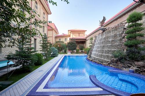 a swimming pool in a yard next to a building at Rakat Plaza in Tashkent