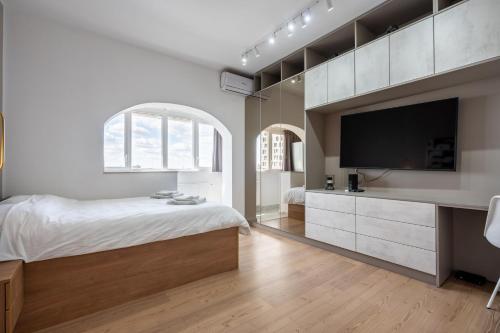 a bedroom with a large bed and a flat screen tv at Sunset - Luxury Studio on Calea Victoriei in Bucharest