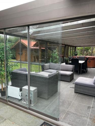 a patio with couches and a table in the background at De Reinakker Bungalow in Sint-Gillis-Waas