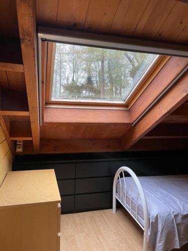 a bed in a room with a window at De Reinakker Bungalow in Sint-Gillis-Waas