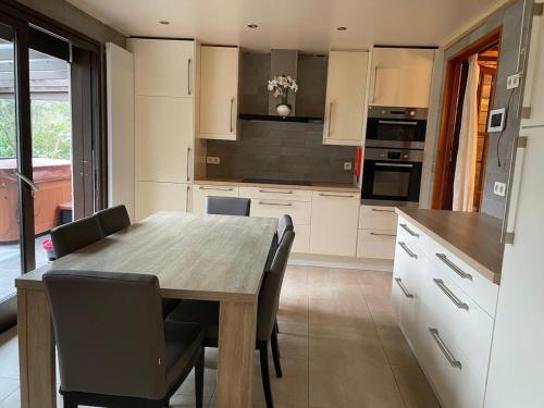 a kitchen with a wooden table and chairs at De Reinakker Bungalow in Sint-Gillis-Waas