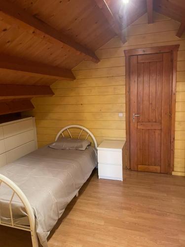 a bedroom with a bed and a wooden wall at De Reinakker Bungalow in Sint-Gillis-Waas