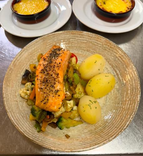 a plate of food with a piece of fish and potatoes at Hotell Maritim Skjervoy in Skjervøy