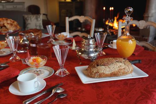 - une table avec un chiffon de table, un gâteau et du jus d'orange dans l'établissement Le Pommier Doux, maison d'hôte du Domaine du Château d'Argeronne, à La Haye-Malherbe